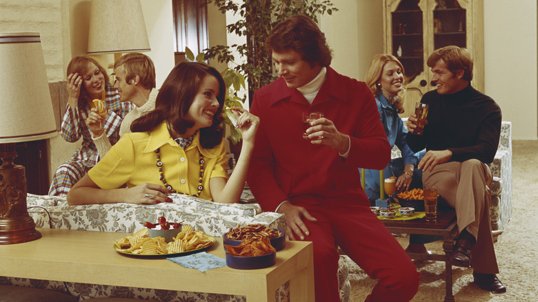 Group of people in the 1970s eating and drinking