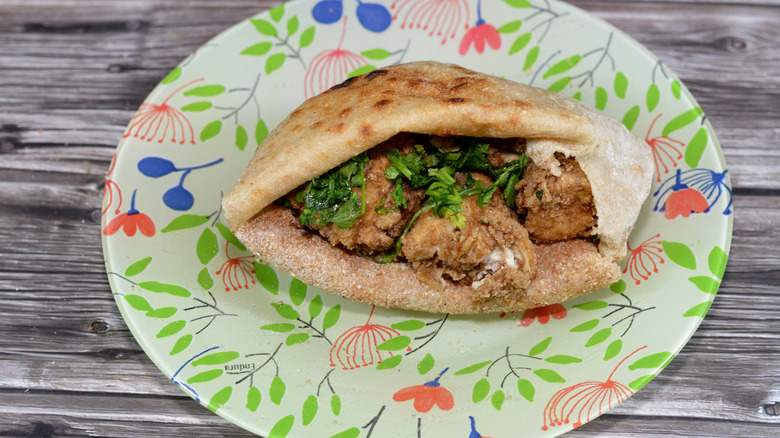 Fried cow brains in a pita on a paper plate