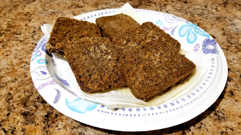 A paper plate with five scrapple patties