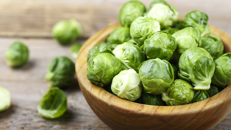 Wooden bowl filled with raw Brussels Sprouts