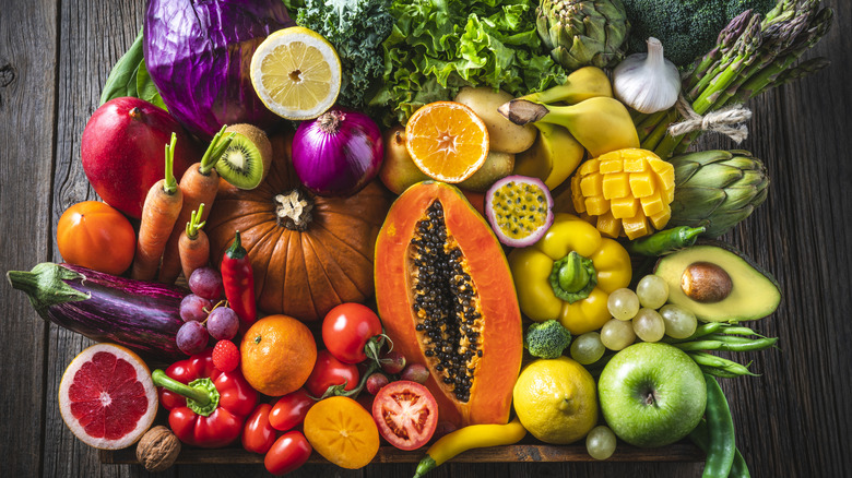 Rainbow of fruits and veggies in front of wooden table