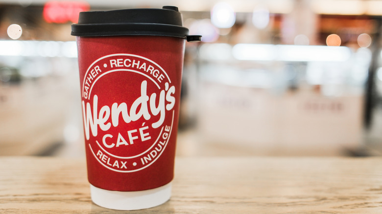 Red Wendy's cup of coffee on wooden table