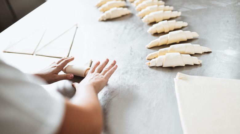 A baker shaping dough for croissants.