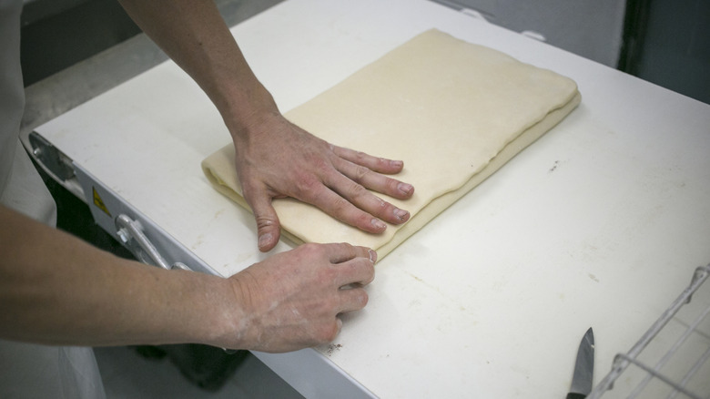 A baker preparing dough for croissants.