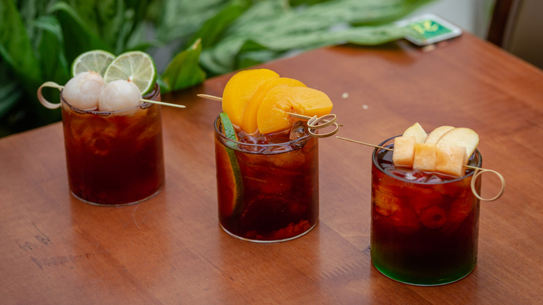 Glasses of iced cold brew with fresh fruit garnishes