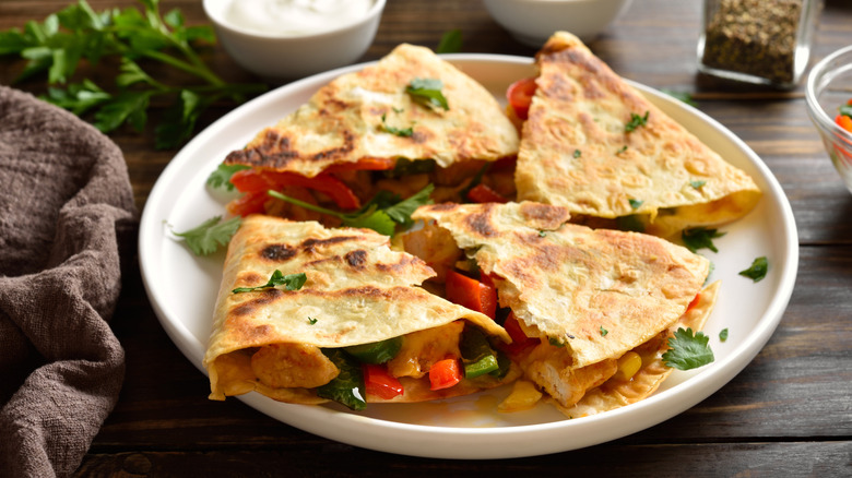 A plate with a sliced quesadilla sitting on it.