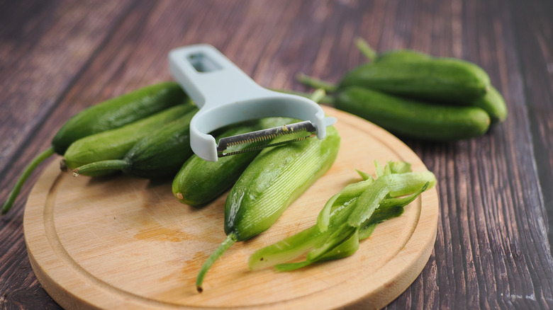 Cucumber peeling and preparation on a cutting board.