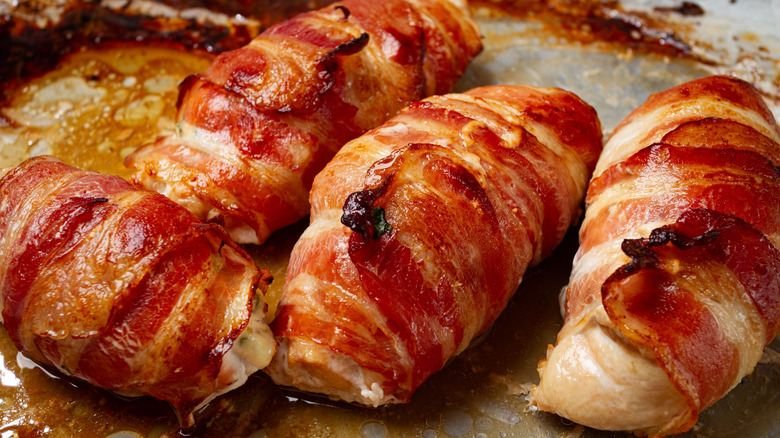 Crispy bacon wrapped around small chicken breasts