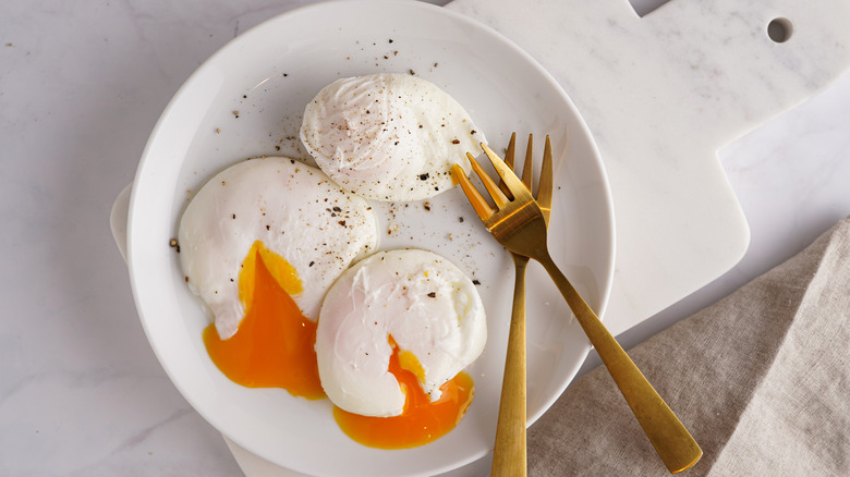 three poached eggs on a white plate