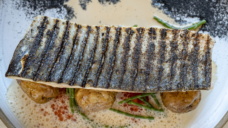 grilled fish with crispy skin on plate