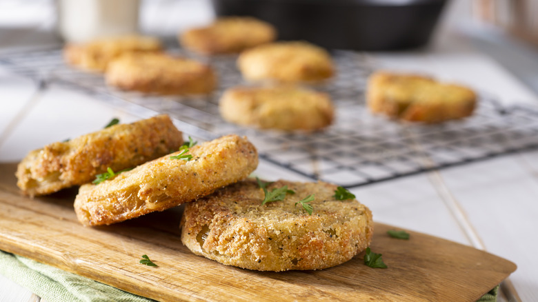 Fried green tomatoes with a wire rack in the background