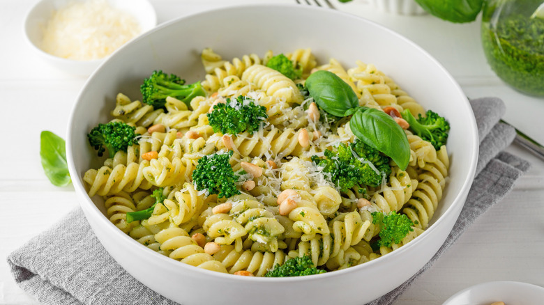 A bowl of pesto pasta made with broccoli, pine nuts, parmesan, and fresh basil.