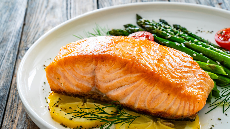 Salmon with asparagus and lemon on a white plate