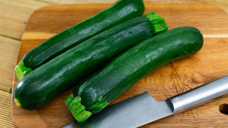Zucchini on wooden cutting board with knife