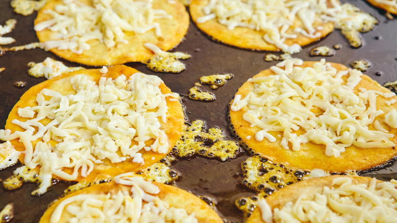 Corn tortillas with melting cheese on flat top griddle