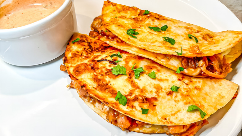 Crispy quesadillas on white plate with chipotle dipping sauce