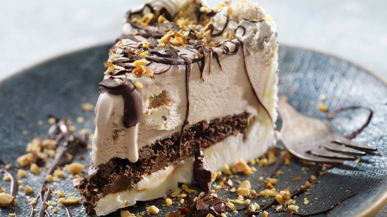 Ice cream cake with crushed nuts and chocolate drizzle