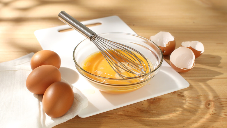 Egg mixture in bowl with whisk