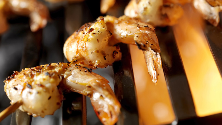 A close-up of skewered shrimp cooking on a grill