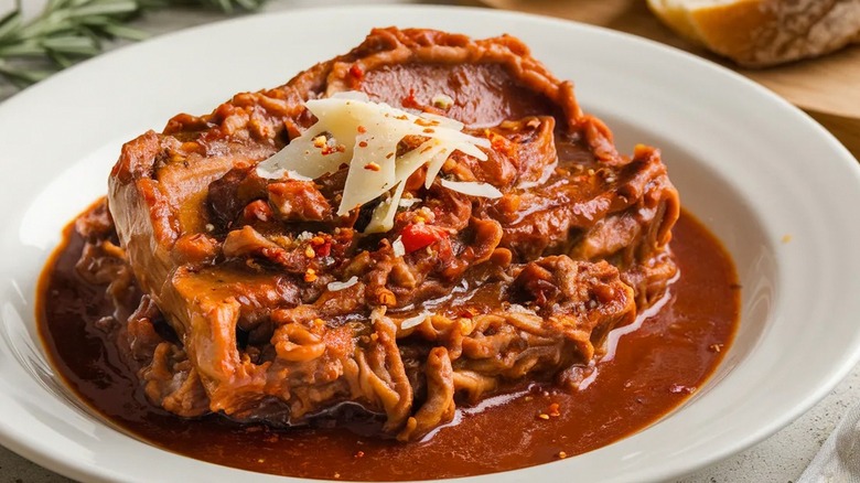 Italian stracotto with shaved parmesan in white dish