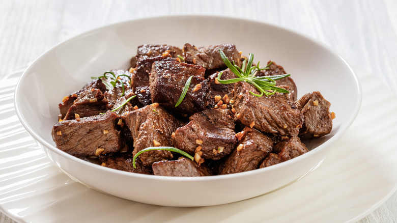 A white bowl full of seasoned steak bites