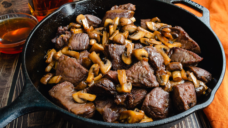 Beef tips and mushrooms in a black cast iron pan