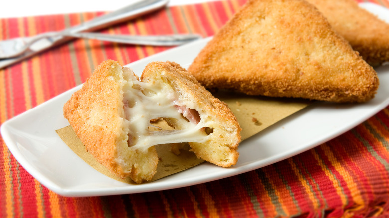 Three fried mozzarella sandwiches on a plate