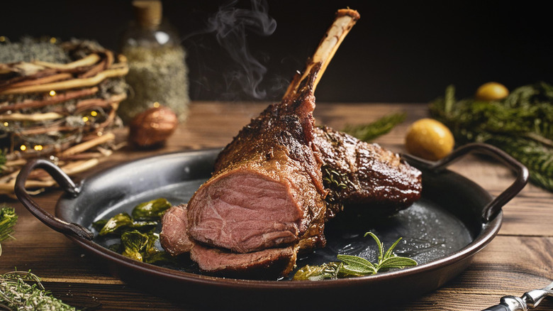 Roasted leg of lamb in a cast iron dish with herbs