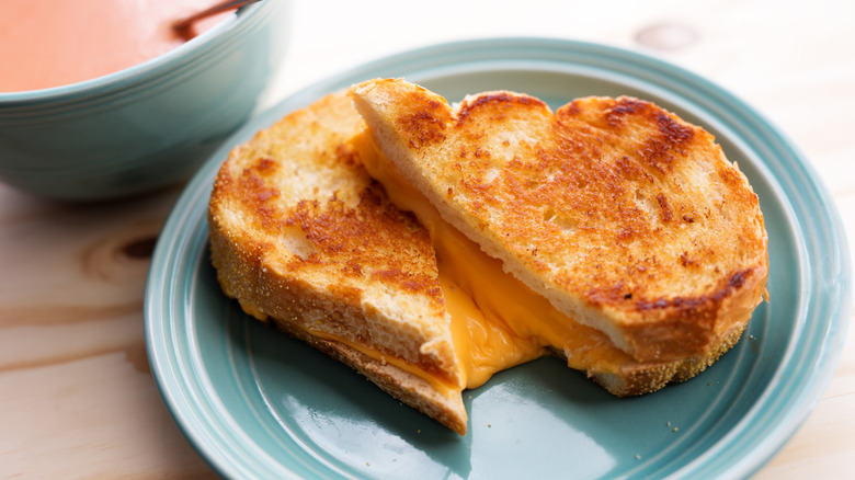 Halved grilled cheese sandwich on a blue plate