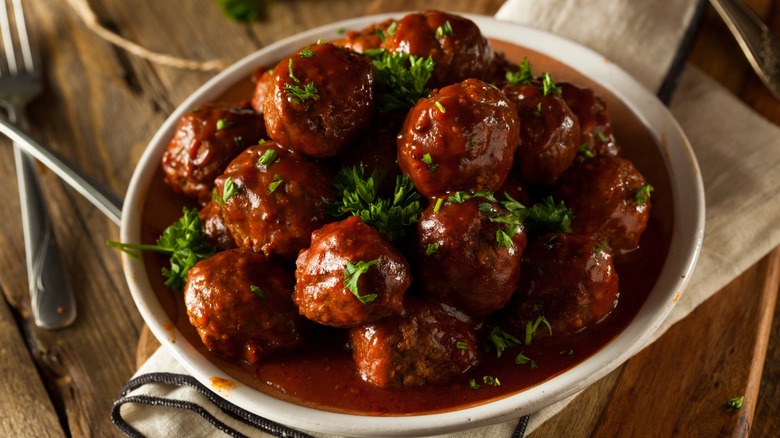 BBQ meatballs topped with parsley in white bowl