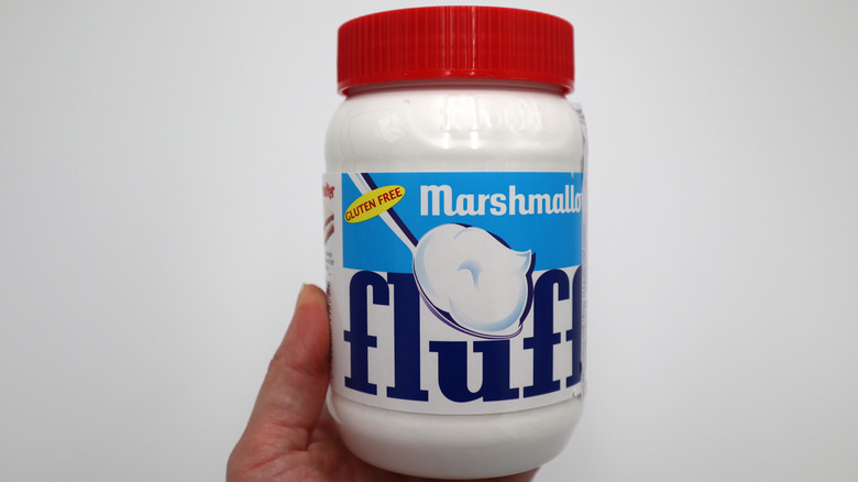 Hand holding a jar of Marshmallow Fluff