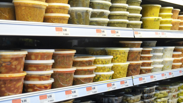 Store shelves stacked with food in deli containers