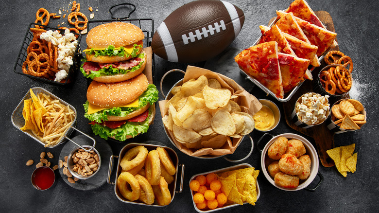 A spread of food with a football on a black background.