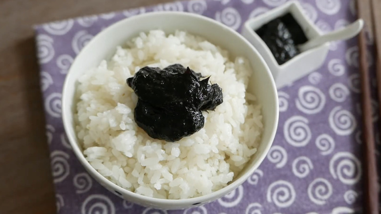 A bowl of white rice topped with seaweed paste.