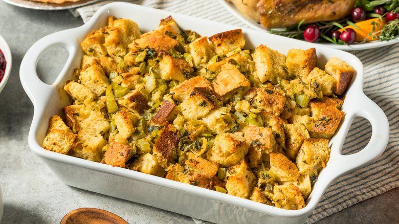 Thick Thanksgiving stuffing in a white casserole dish.