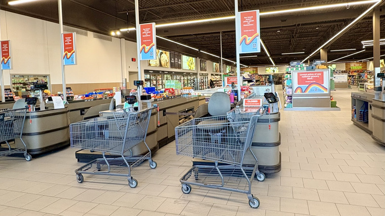 Woman smiling in grocery aisle as she looks at her reciept