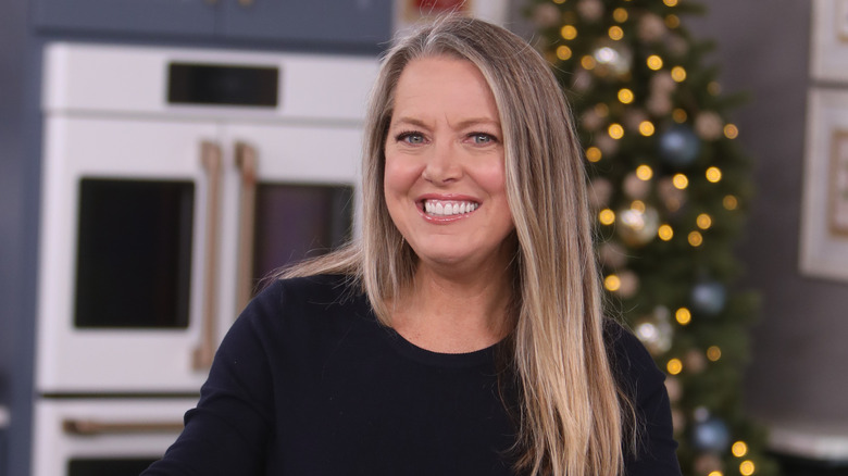 Melissa D'Arabian smiling in a kitchen by a Christmas tree