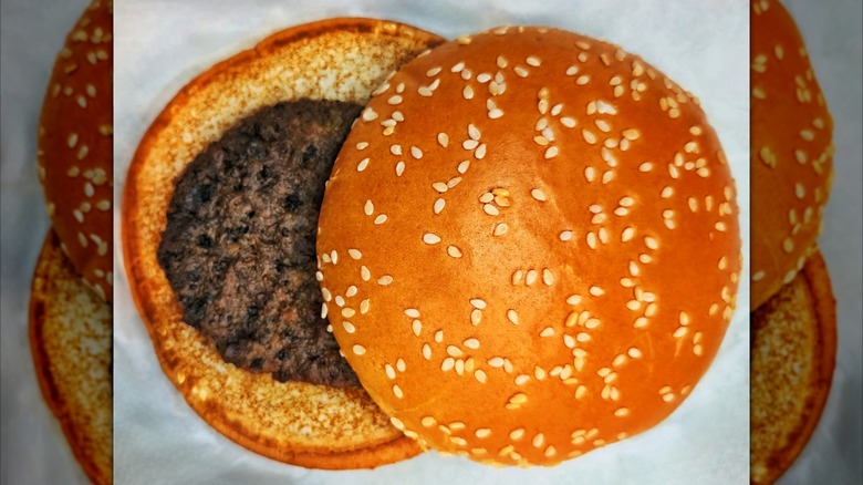 Burger with top bun askew showing small burger patty