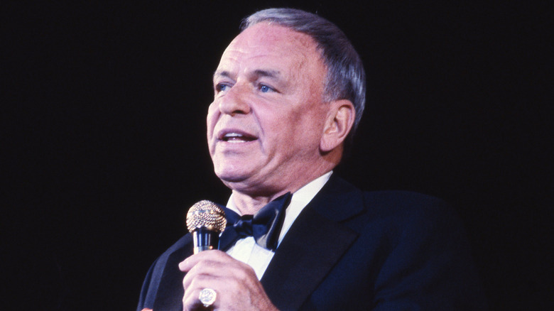 A picture of the legendary crooner Frank Sinatra performing on stage.