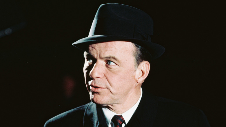 Frank Sinatra wearing a black hat and tie