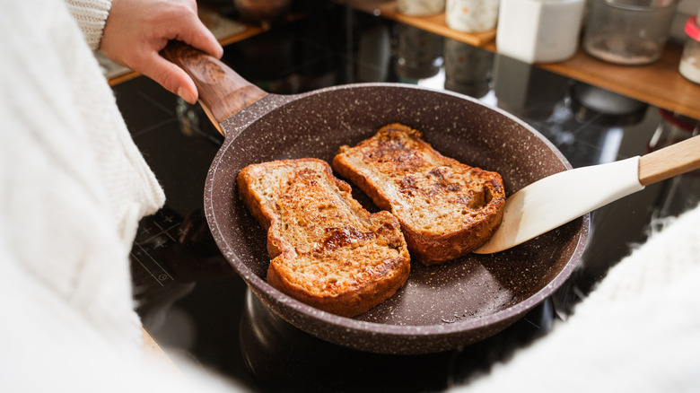 Someone frying French toast in a pan at home.