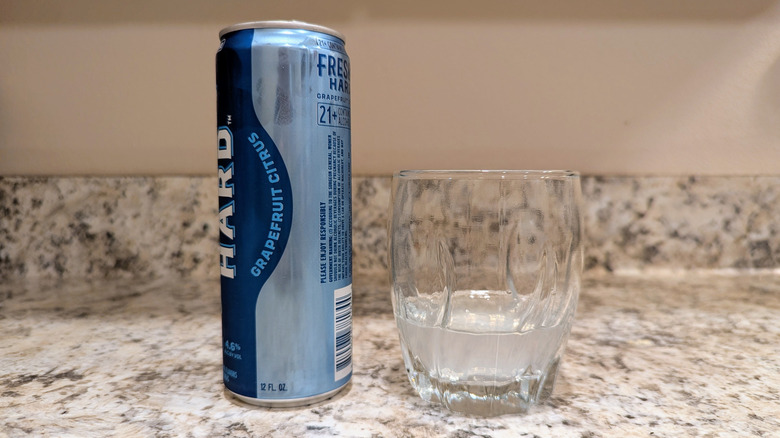 Original flavor Hard Fresca on counter with glass next to it.
