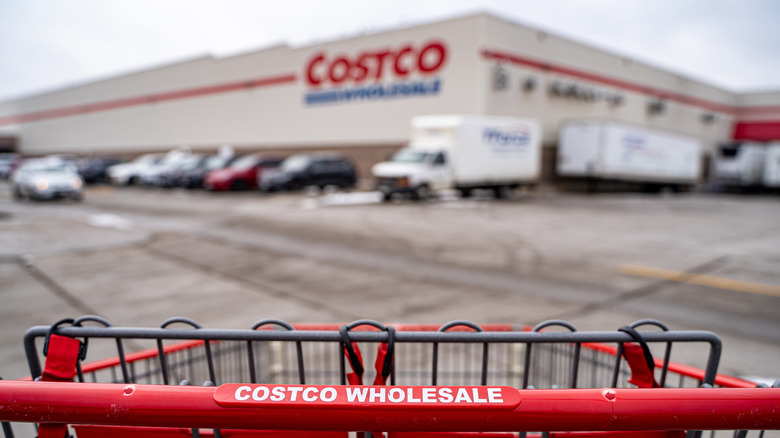 Costco wholesale shopping cart in parking lot with a Costco warehouse in background