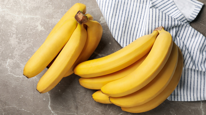 Yellow bananas laying on a kitchen towel
