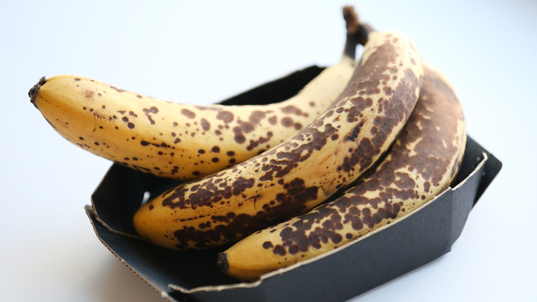 Brown speckled bananas in a cardboard box