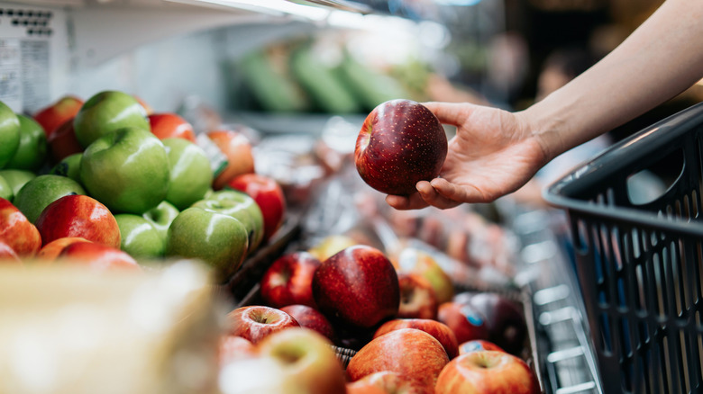 Hand grabbing an apple in store