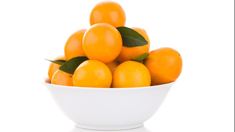 White bowl with oranges and leaves