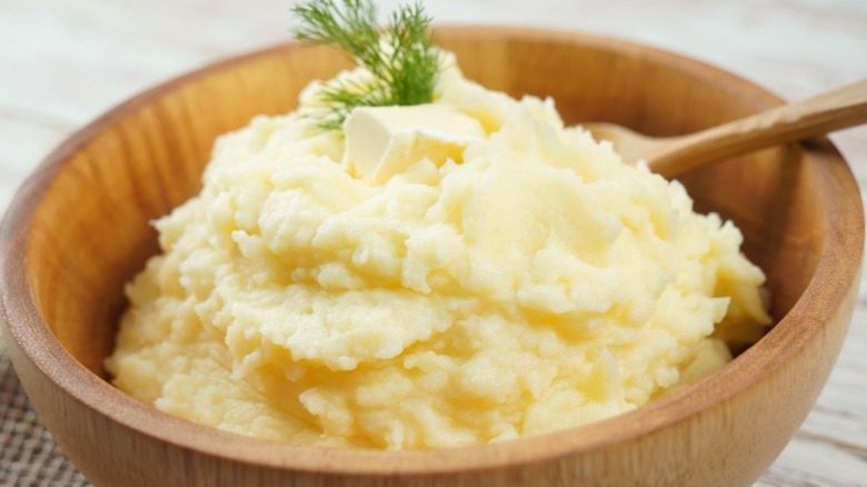 A wooden bowl of mashed potatoes.