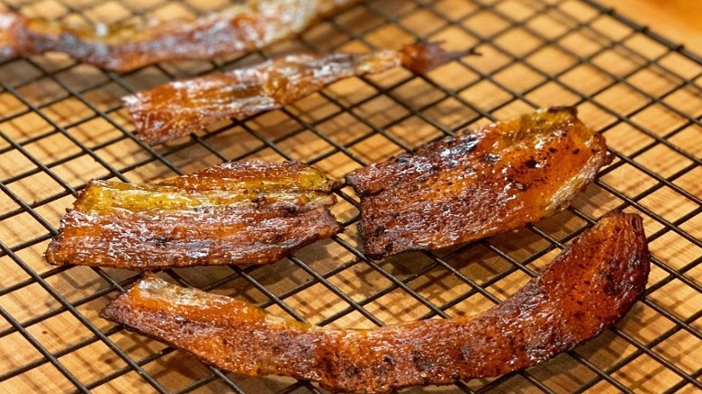 crispy strips of banana peel bacon on a black wire rack on a counter
