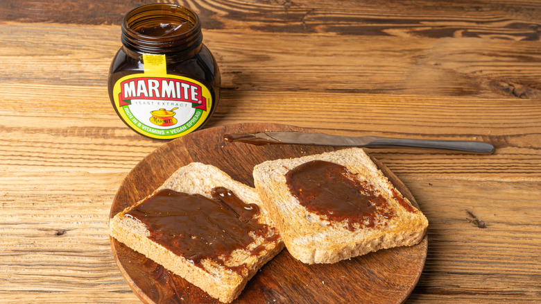 Toast with Marmite on top with a jar of Marmite behind it.